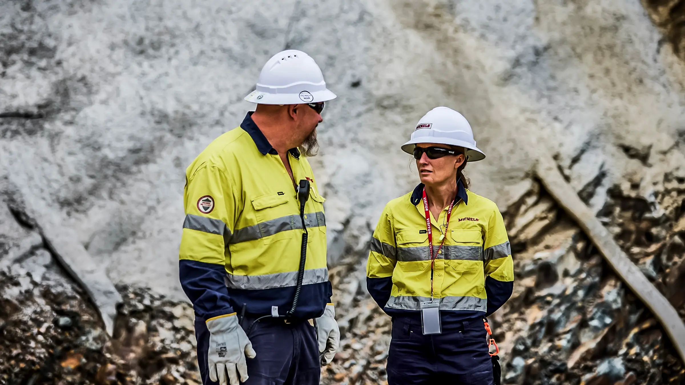 A man and woman talk on a jobsite.