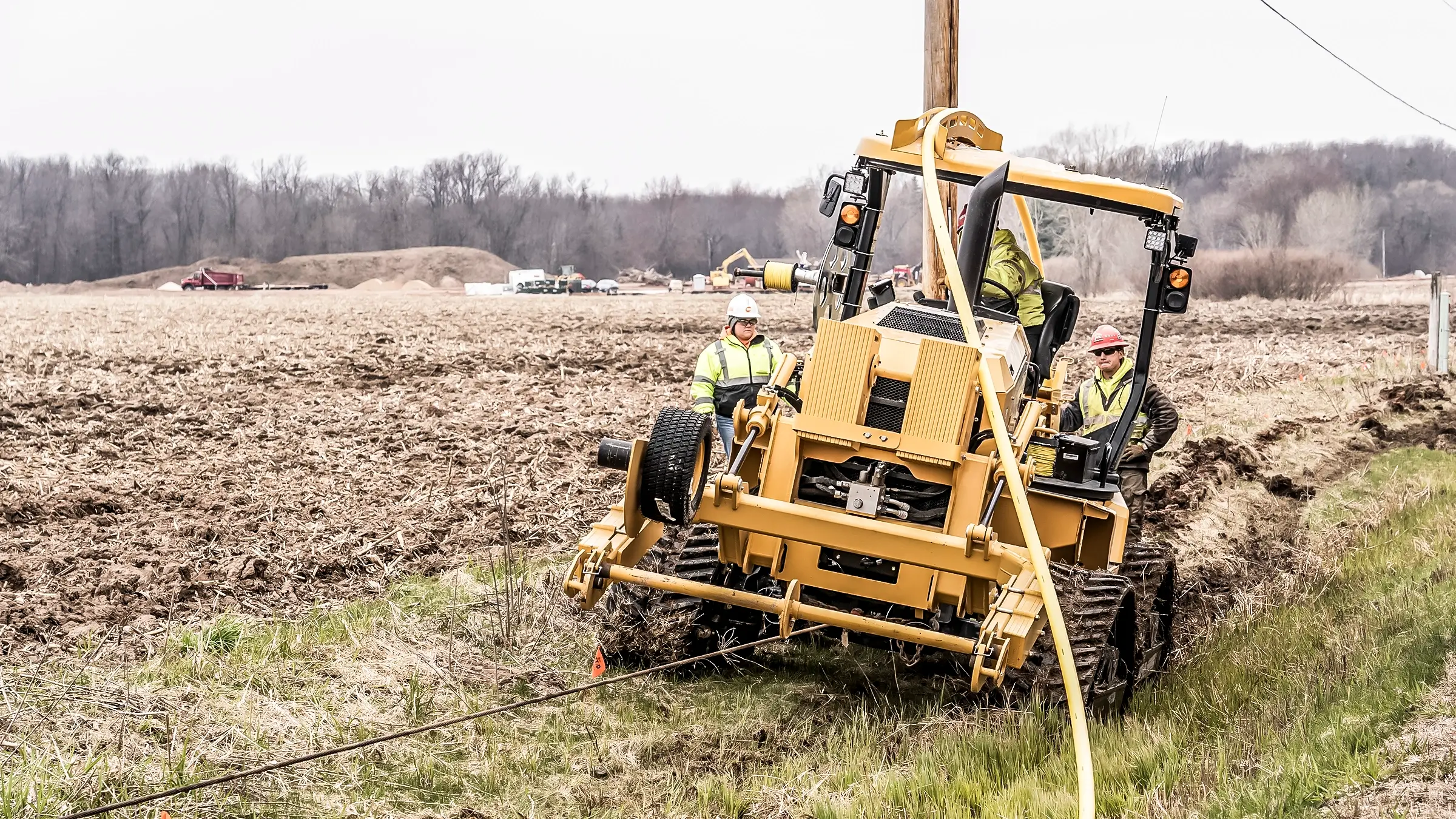 A utility plow installs cable near a roadside.