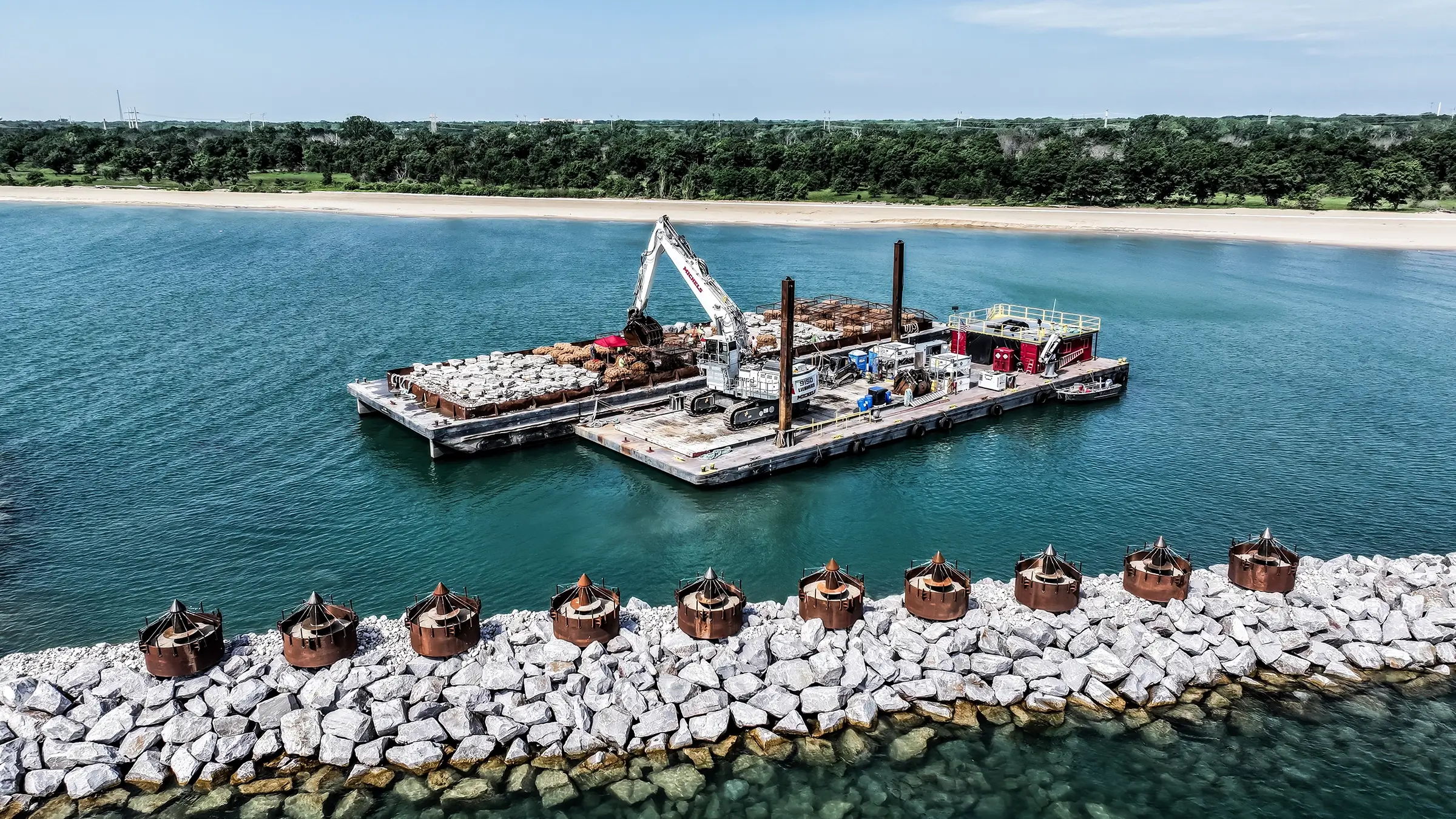 A platform barge carries an excavator off the coast of Lake Michigan