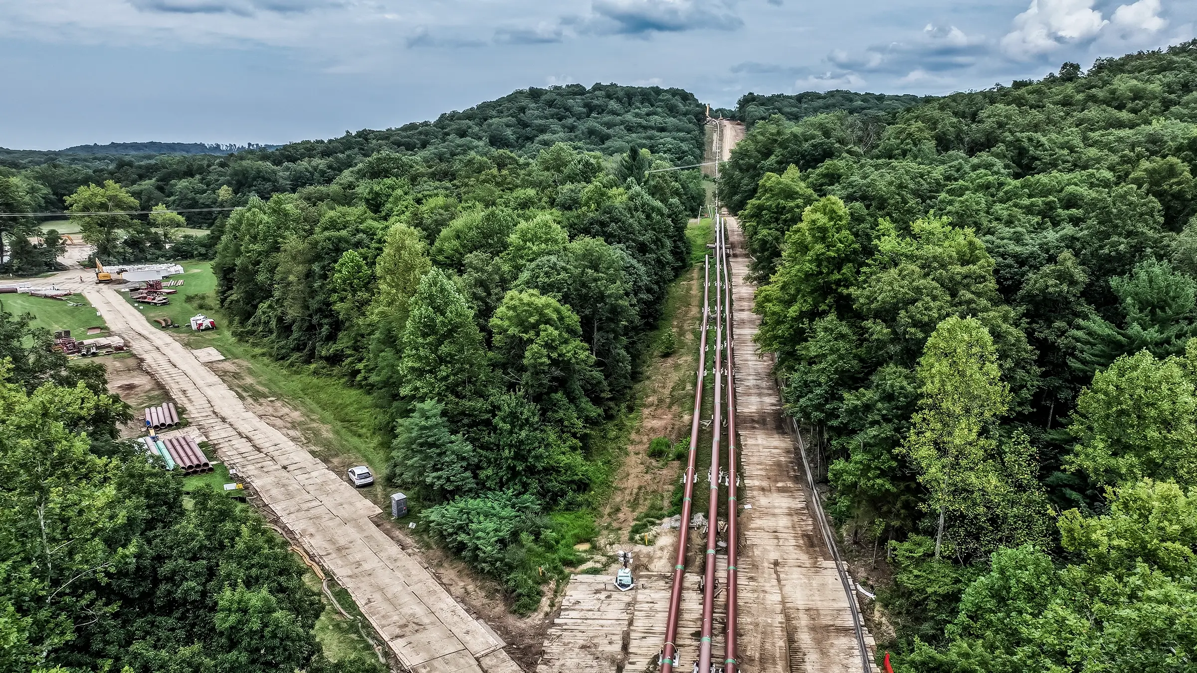 Large diameter pipelines spanning through a forested hillside.