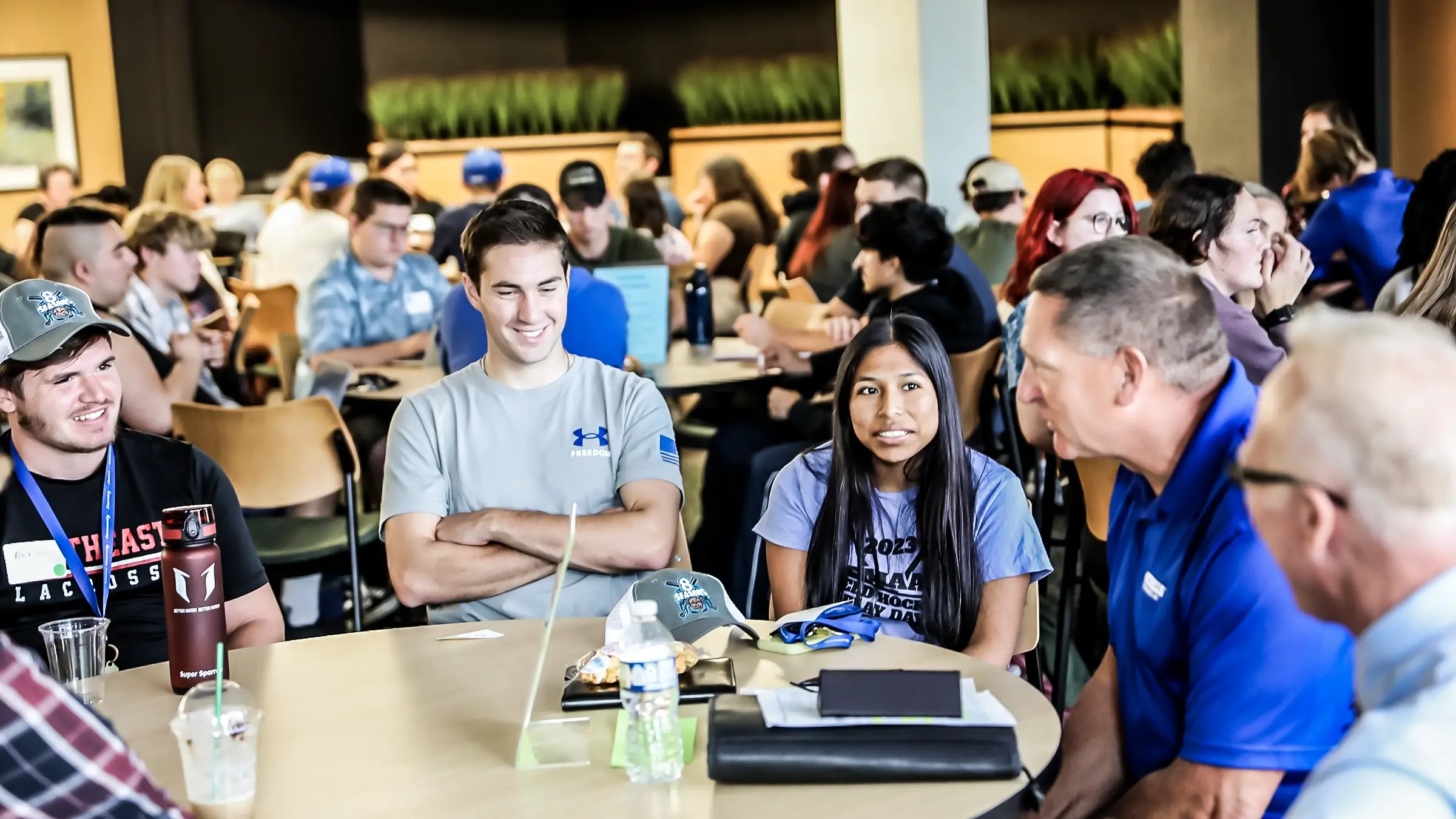 Several students sit around a table smiling.