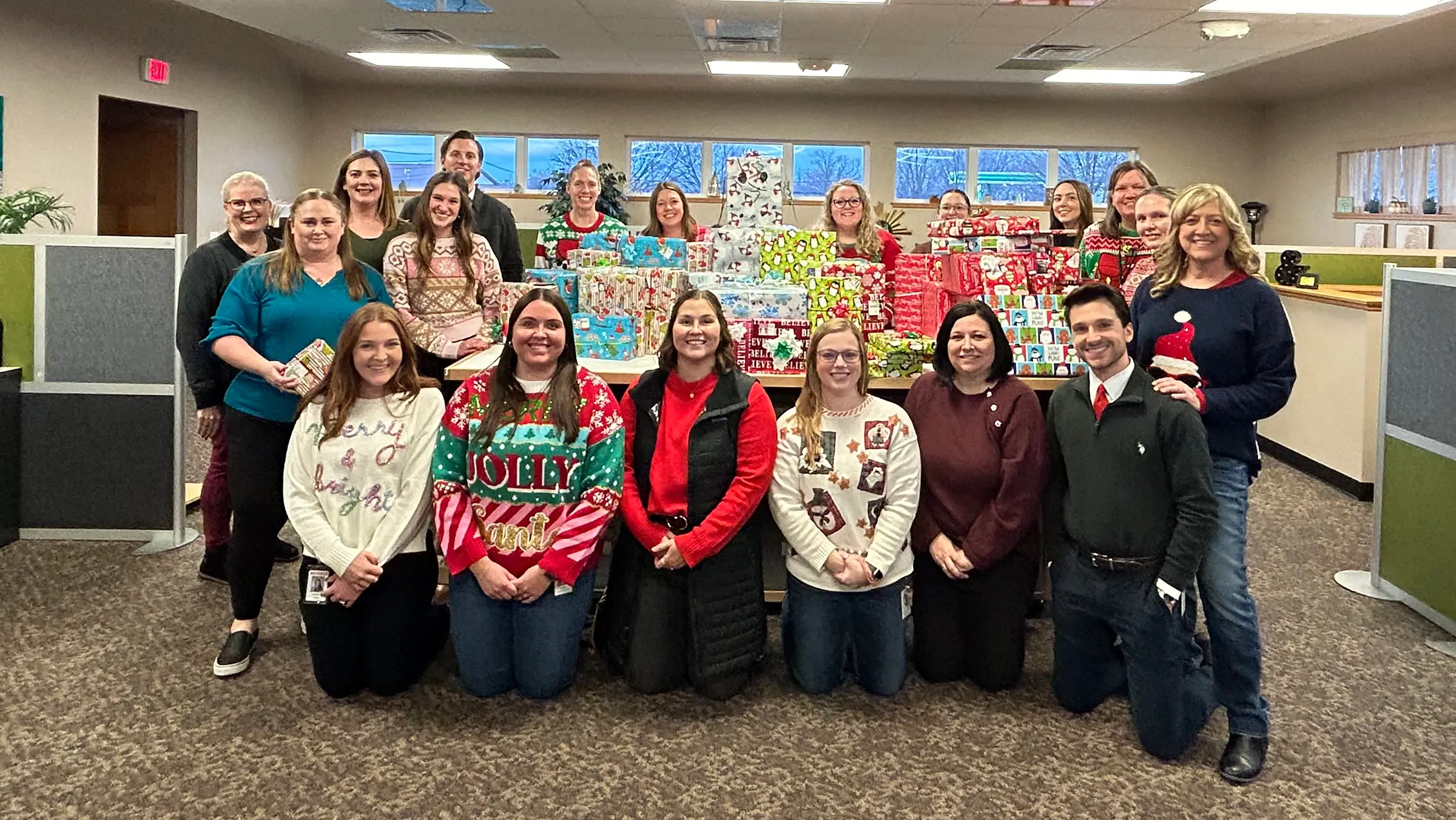 Michels marketing team stands around a pile of wrapped gifts.